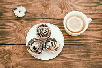 Biscuits with powdered sugar and hot tea with lemon.