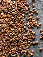 Roasted coffee beans on the old wooden background. Top view.