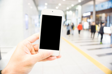 Blurred people rush hour in train station with smartphone blank screen