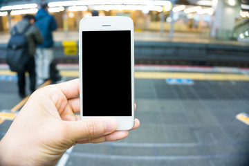 Blurred people rush hour in train station with smartphone blank screen