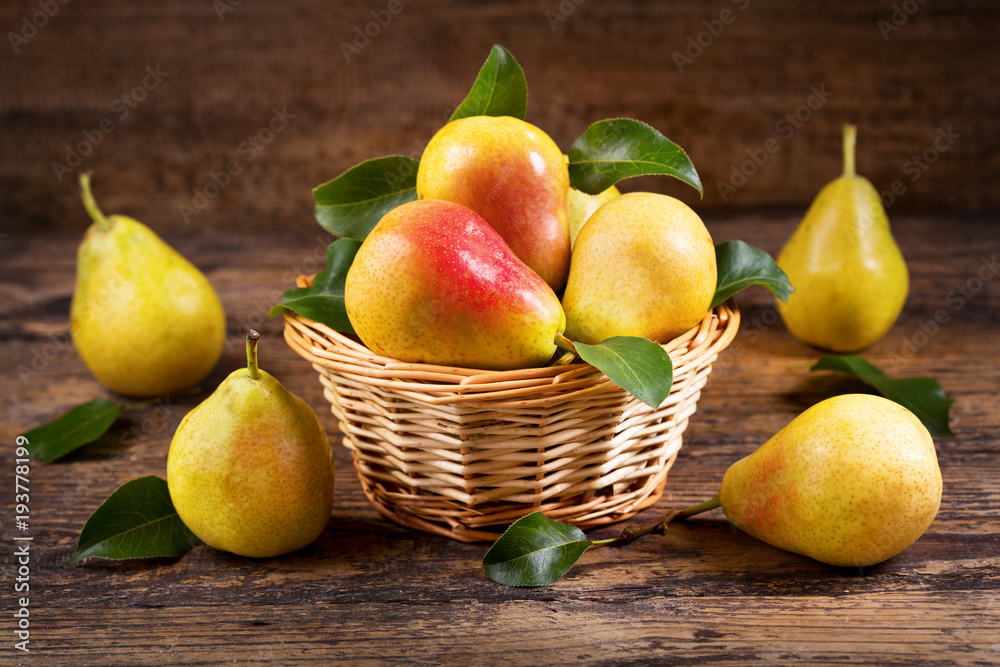 Wall mural fresh pears with leaves in a basket