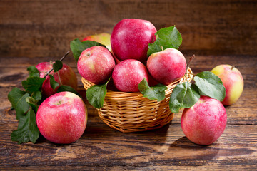fresh red apples with leaves in a basket