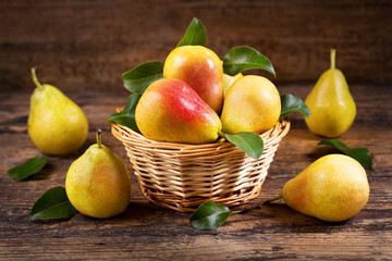 fresh pears with leaves in a basket
