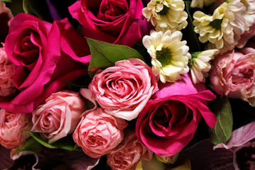 Beautiful spring bouquet of flowers close-up on a pink background. Bouquet of roses, chrysanthemums, lilies.