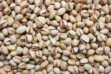 Pistachio Nuts in Shell Textured Background. Pile of Fresh Green Roasted and Salted  Pistachios Top View. Healthy Organic Nutritious Nuts,  Vegetarian and Vegan Food Snack on the Table.