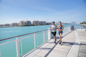 Couple jogging on Miami south beach waterfront pier