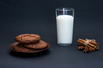 Homemade cookies on a clay plate. Homemade milk in a glass.