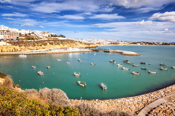Obraz premium port with boats and yachts in Albufeira, a city on the Atlantic coast in Portugal, at sunset. Beautiful sea city landscape