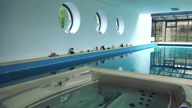 An indoor swimming pool and a whirlpool bath in a luxurious house
