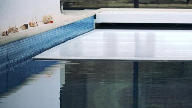 An automatic cover rolls over an indoor swimming pool