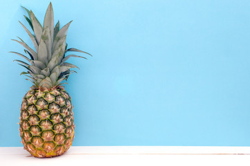 Fresh pineapple on a bright turquoise background (copy space)