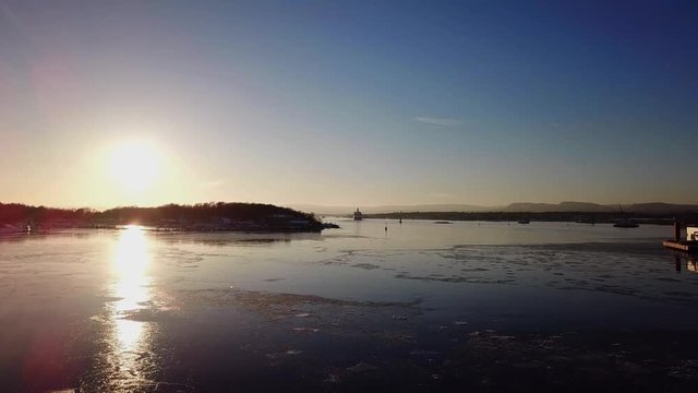 Aerial shot of islands in Oslo fjord towards sun at sunset in winter