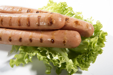 Wurstel on a bed of salad with white background