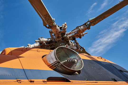 А swashplate of the rotor blades of the helicopter and exhaust pipe engine against the blue sky