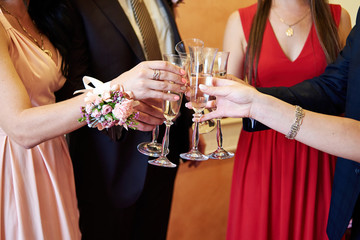 People holding glasses of champagne and making toast. Clinking glasses of champagne in hands. Happy festive moment, holidays, celebration concept. New year. Champagne party