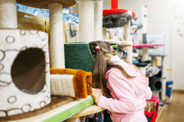 Little girl chooses supplies for cat in petshop