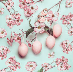 Easter pastel pink pattern with hanged eggs and decor blossom on turquoise background