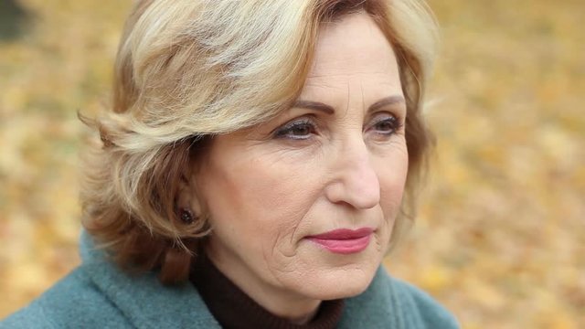 Close-up of attractive thoughtful, calm middle-aged woman, looking into distance