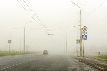 Dense fog in summer in city on the highway