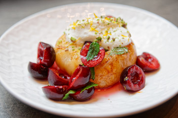 Grilled peach with cherries and whipped cream