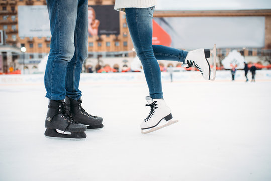 Male and female legs in skates, couple on the rink