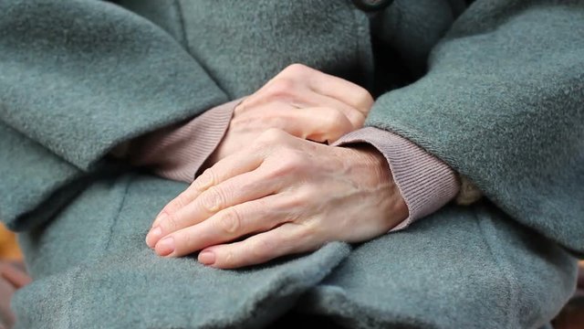 Close up of elderly woman hands, woman rubbing her hands shyly, feeling timidly