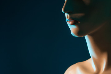 Fragment of a woman's face. Lips of a woman. Profile face on a dark background.