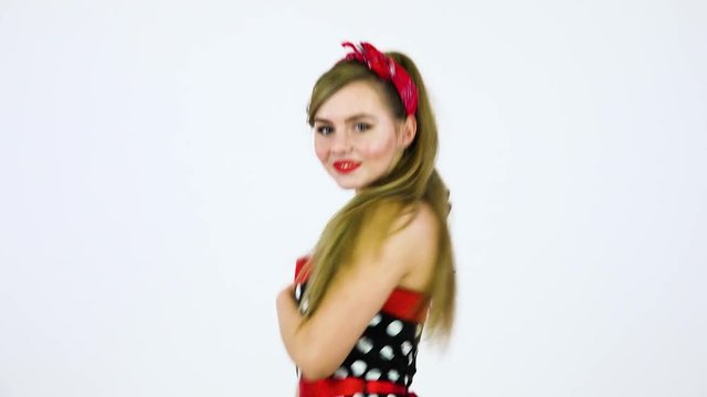 A beautiful 50s pin-up girl dances and smiles at the camera - closeup - white screen background