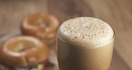 stout beer glass with bagels on background