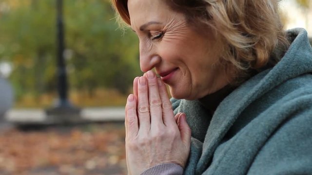 Happy, beautiful, lady with grateful face putting hands together in prayer 's