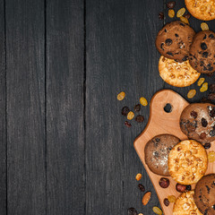 Freshly baked cookies on a wooden table. Lies on a wooden dostichke, around various nuts and raisins.