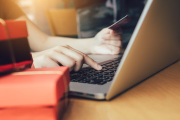 Close up woman hand typing on keyboard laptop and holding credit card with shopping online.