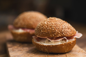 prosciutto and cream cheese in a sesame buns on wood board