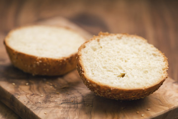 sliced sesame bun on wood board