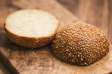 sliced sesame bun on wood board