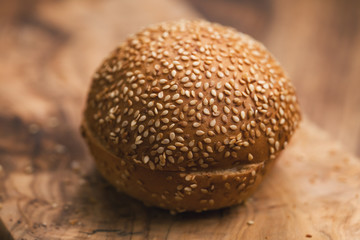 sliced sesame bun on wood board