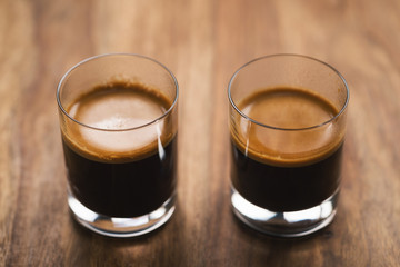 two shots of espresso on wood table