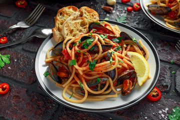 Homemade Pasta Spaghetti with mussels, tomato sauce, chilli and parsley on rustic background. sea food meal