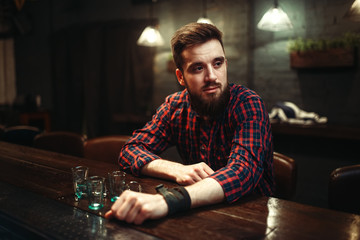 Sad man sitting at bar counter, alcohol addiction