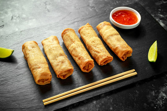 Chinese vegetable spring rolls with lime wedges, sweet chilli sauce.