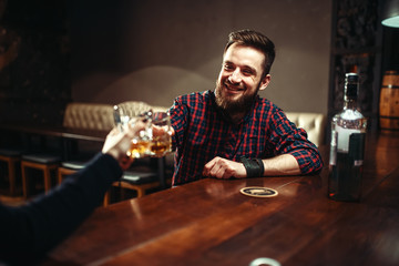 Two men clink glasses, friends drink alcohol