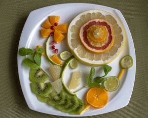 Fruit flower - citrus, kiwi and pomegranate with mint decoration.