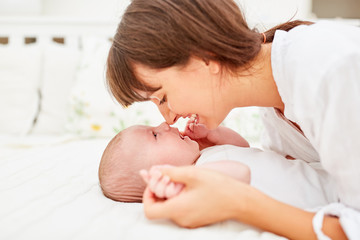 Obraz na płótnie Canvas Glückliche Mutter kuschelt mit ihrem Baby