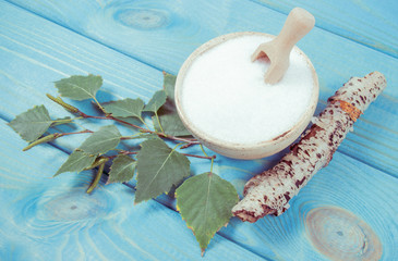 Xylitol - sugar substitute. Birch sugar on blue wooden background.
