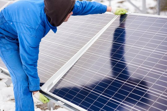 Horizontal shot of a technician worker adjusting solar panel outdoors installing photovoltaic system alternative electricity energy source environmental care consciousness technology.