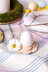 egg in a wooden stand with floral elements - elements of the Easter festive table, serving option