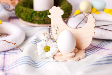 egg in a wooden stand with floral elements - elements of the Easter festive table, serving option