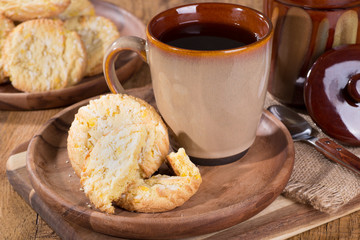 Lemon crackle cookies and cup of coffee on a wooden plate