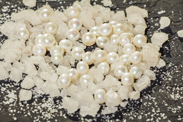 Sea salt on a black decorative antique wooden surface. Background Spa. The concept of the resort....