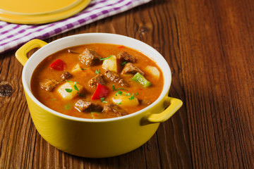 Beef stew served with cooked potatoes.